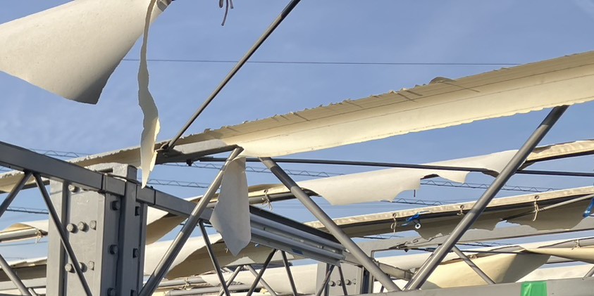 紫外線劣化で白化とひび割れが進んだテント倉庫シートの状態